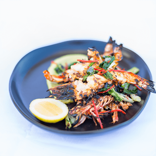 Wild chargrilled Skull Island Tiger Prawns with chilli and garlic oil, avocado mousse and charred greens